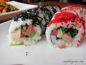These rolls include yellow tail, seared albacore, jalapeño, avocado, cilantro with orange and black tobikko outer covering.